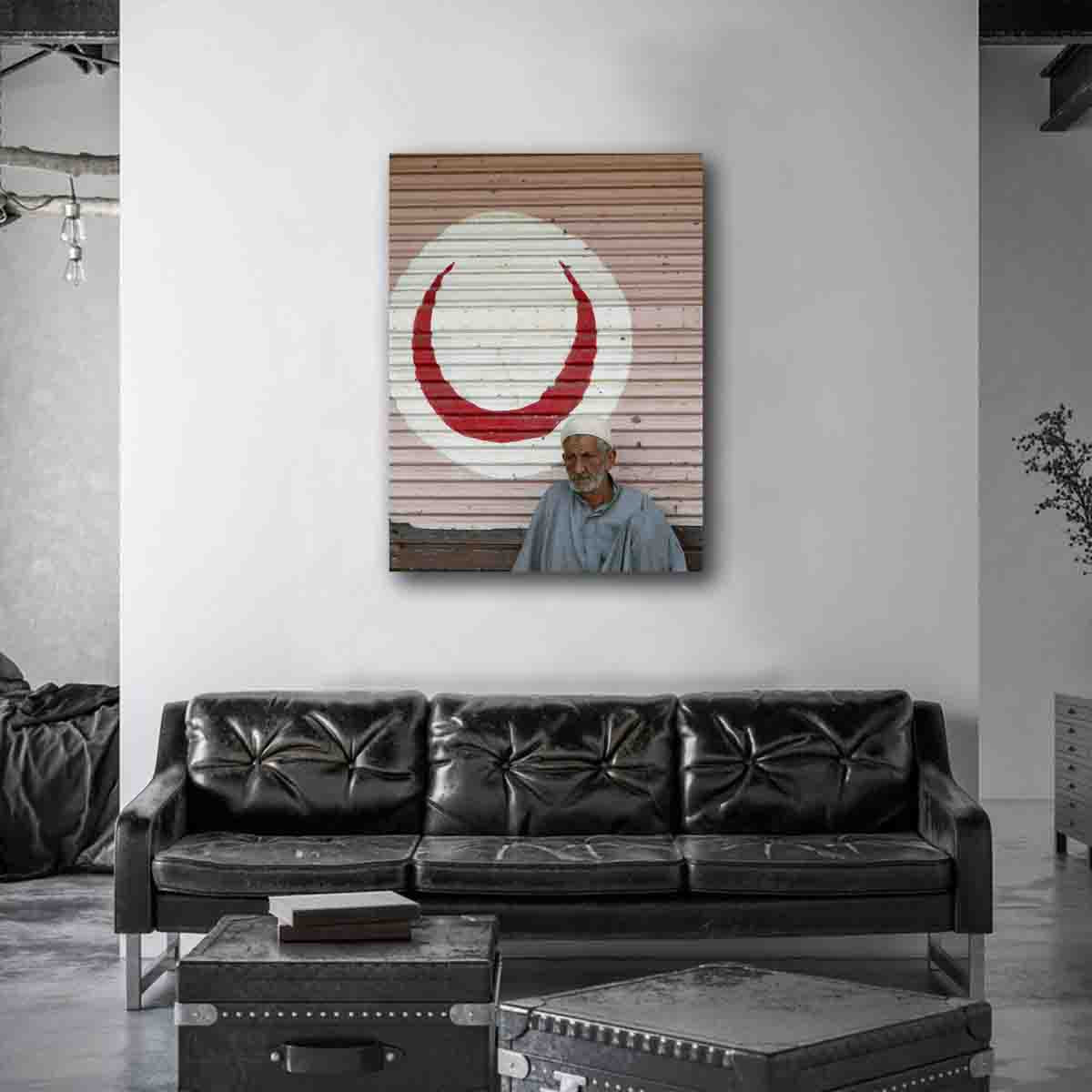 Cairo street portrait of man in front of red crescent, displayed in a modern cultural-inspired interior.