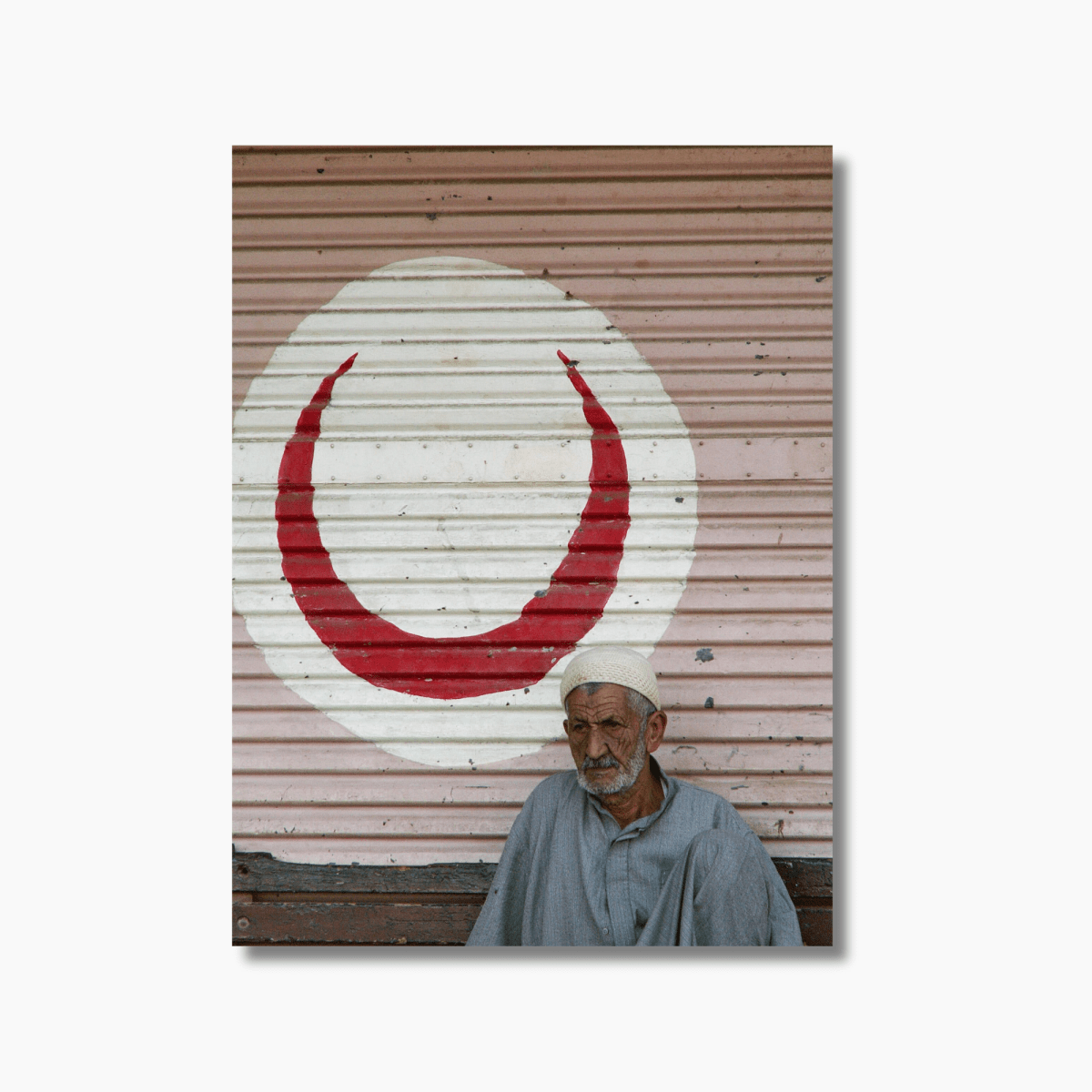 Portrait of elderly man in front of red crescent painted door in Cairo, Egypt — limited edition cultural photography wall art.