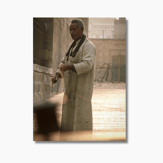 Man in traditional robe flying a kite in Cairo, Egypt — limited edition cultural photography print by Dan Lewin.