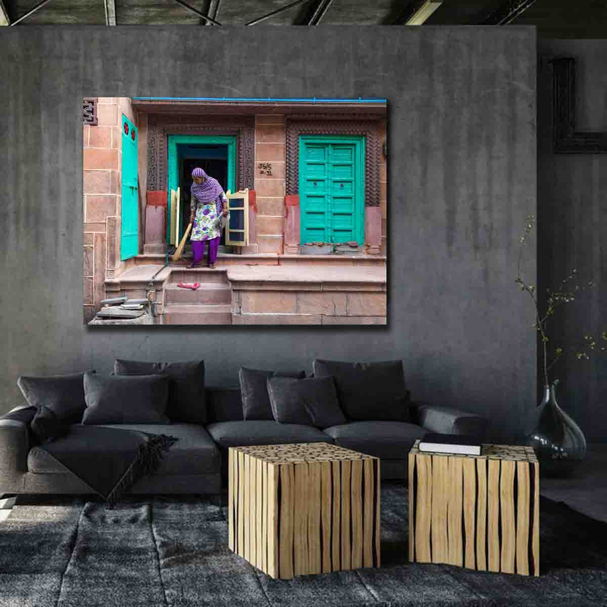 Street scene photograph of a woman sweeping in Jodhpur, displayed as limited edition fine art wall art in a warm, global-inspired interior.