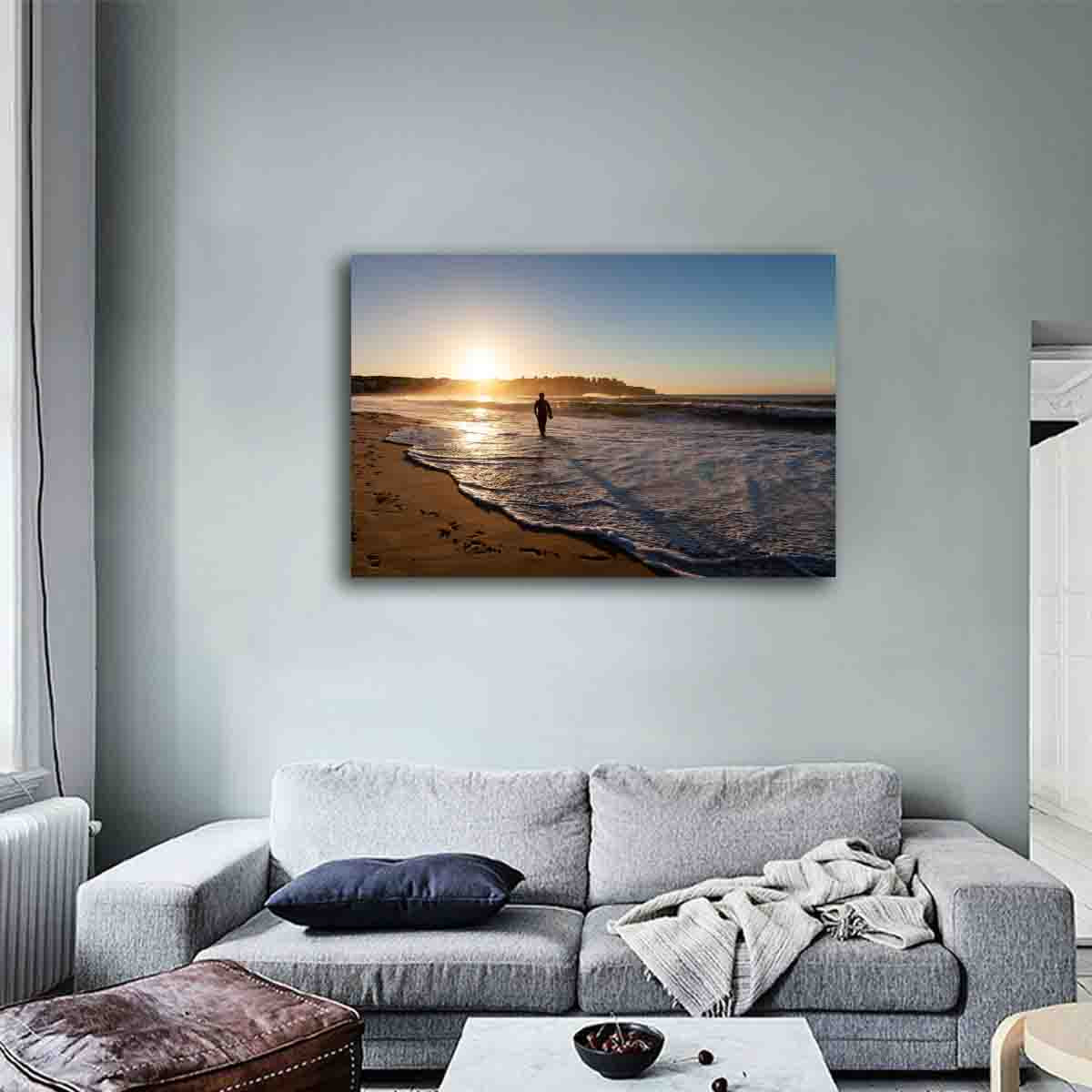 Fine art sunrise photography print of surfer at Bondi Beach, displayed in a calm, coastal-inspired modern interior.
