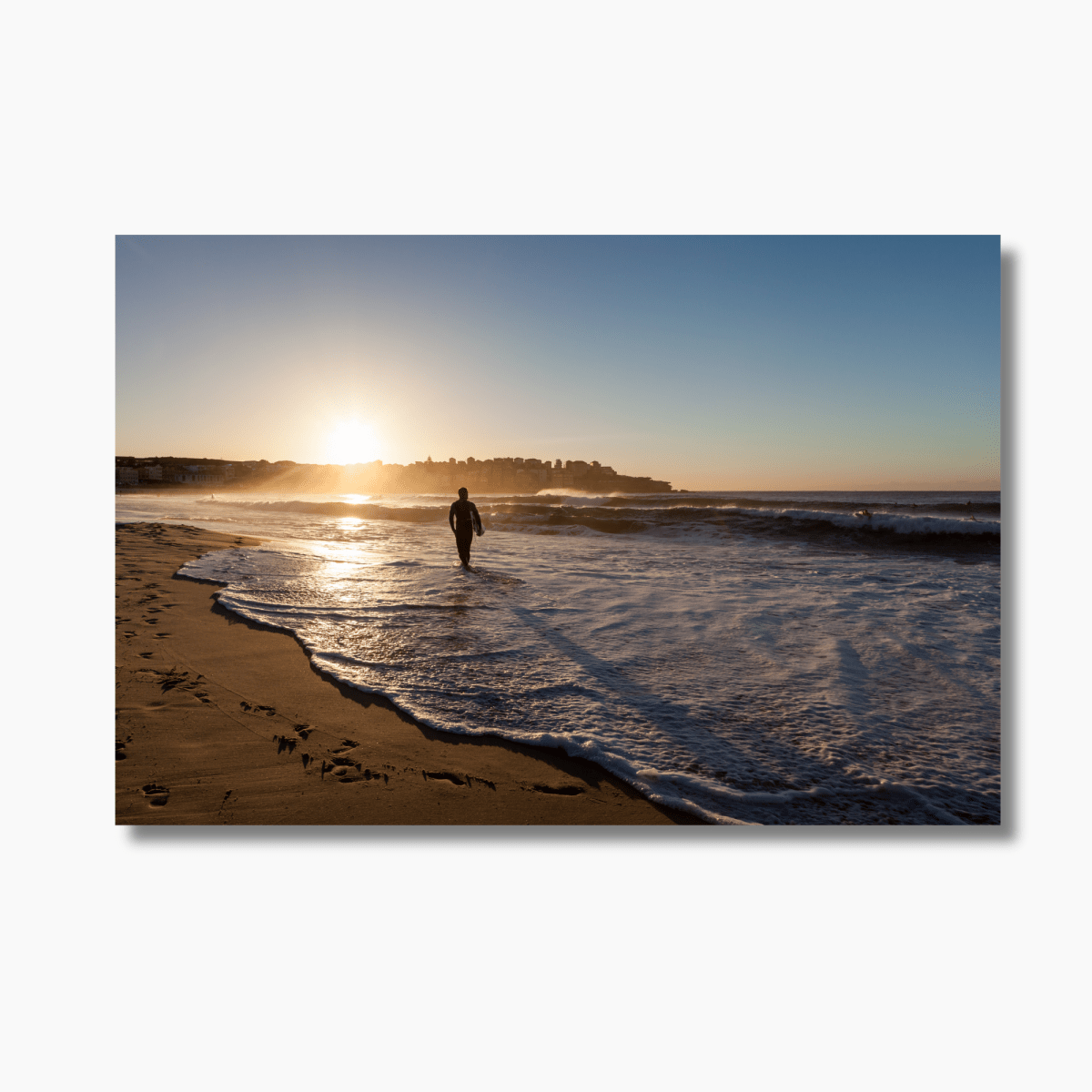 Surfer walking through shallow water at sunrise on Bondi Beach, Sydney — limited edition Australian coastal photography print