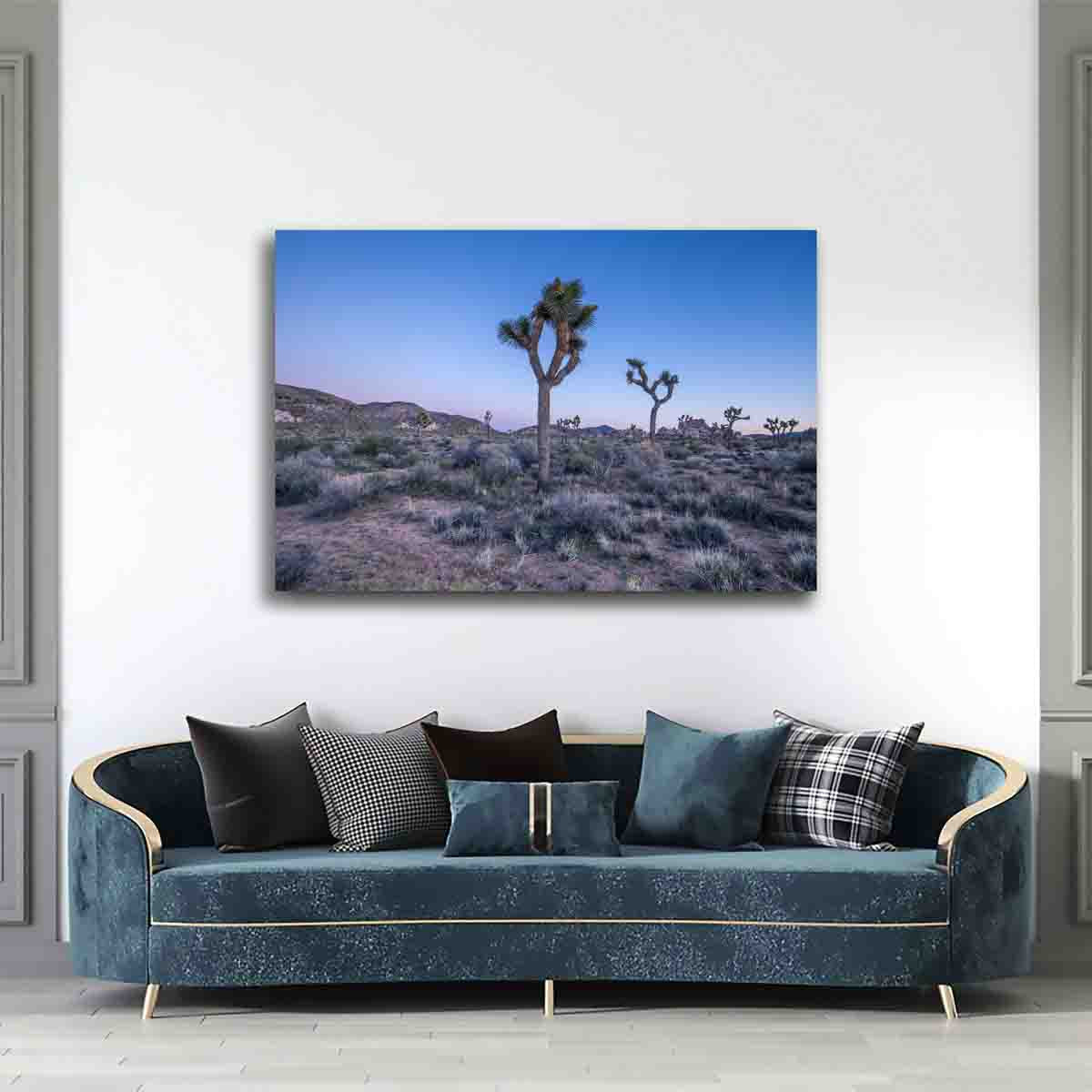 Fine art print of Joshua Tree at sunset, silhouetted against a glowing sky, displayed in a neutral-toned modern living room.