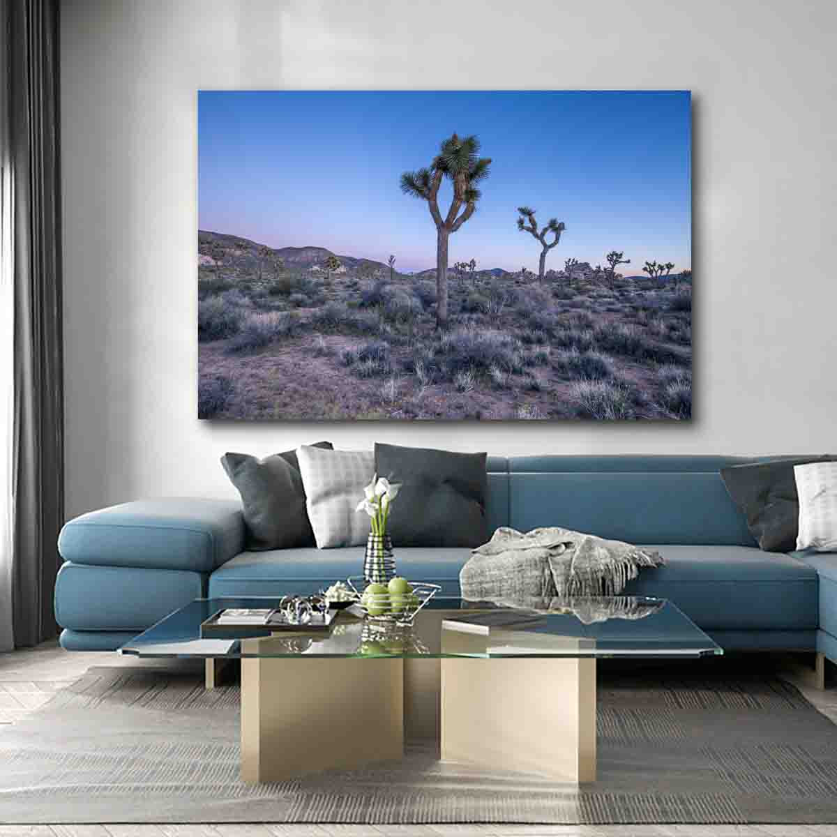 Fine art print of Joshua Tree at sunset, silhouetted against a glowing sky, displayed in a neutral-toned modern living room.