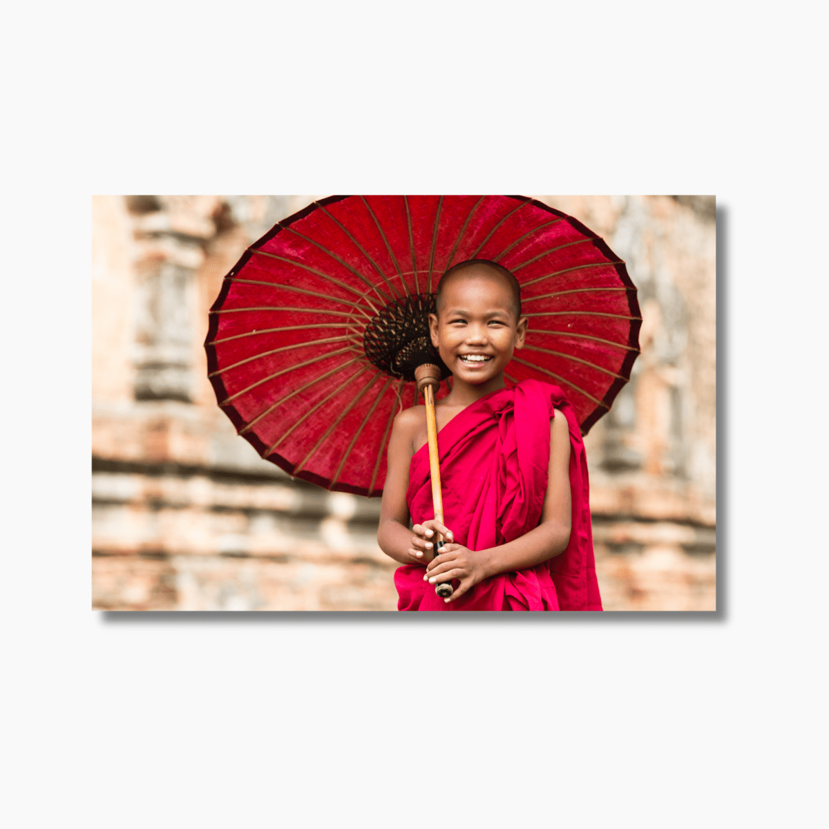 Novice Buddhist monk in Myanmar temple, bathed in natural light—cultural travel photography wall art print.