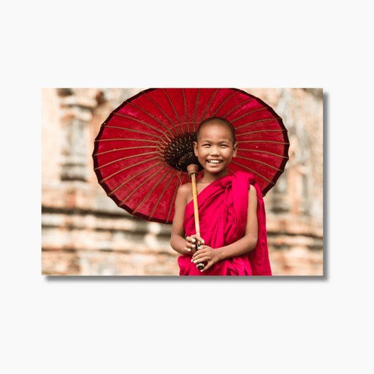 Novice Buddhist monk in Myanmar temple, bathed in natural light—cultural travel photography wall art print.