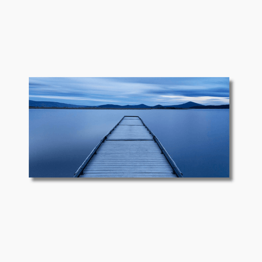 Oregon jetty at sunrise extending over a calm lake, reflecting soft morning light—tranquil Pacific Northwest fine art landscape.